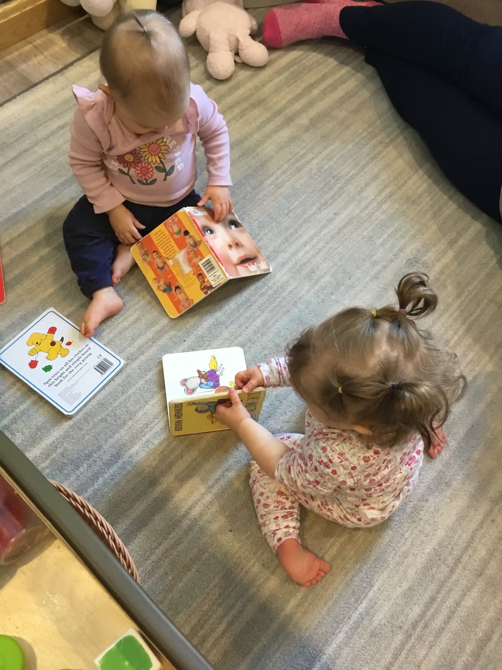 Infants reading books together in the Little Acorns nursery